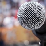 microphone in front of unfocused crowd