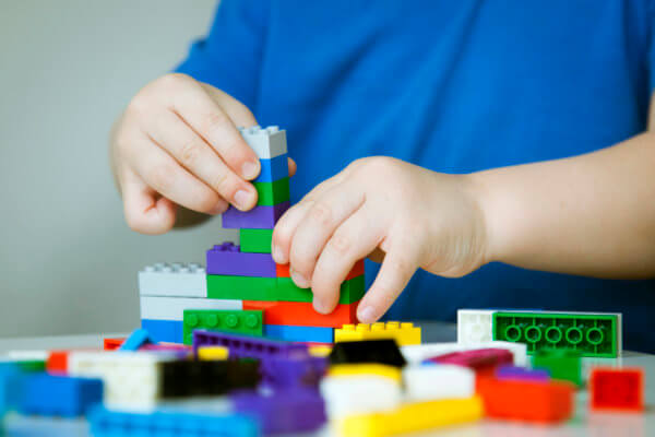 child hands building colorful legos