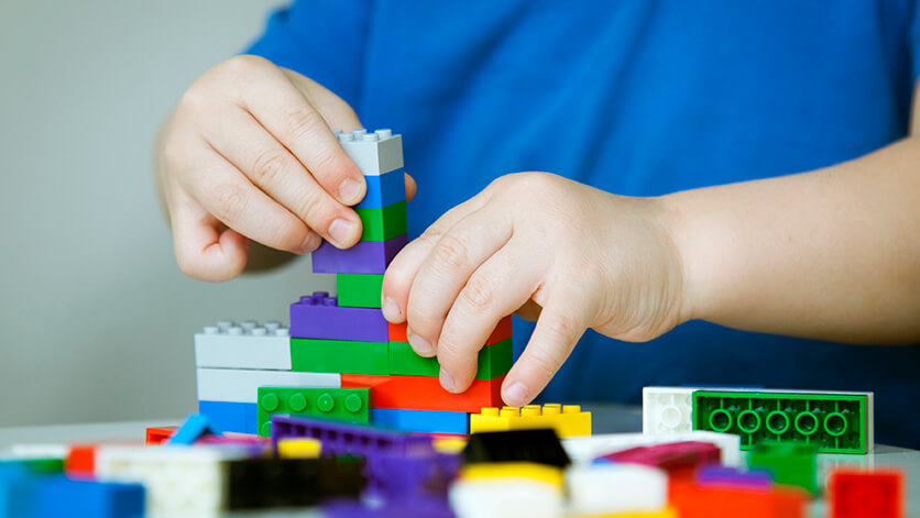 child hands building colorful legos