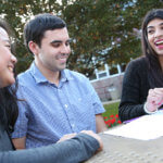 students laughing and studying at picnic table