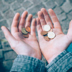 hands holding several coins