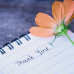 thank you written on a notepad with a flower