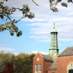 Marian Hall steeple surrounded by spring blossoms