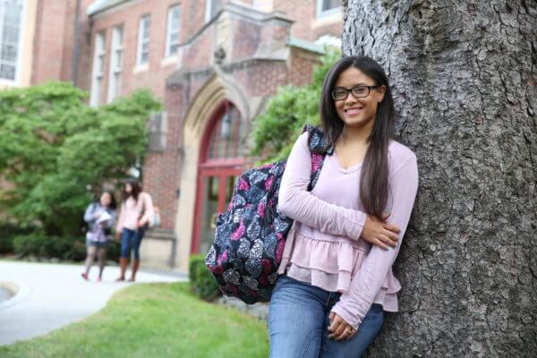 Smiling Student Leaning on Tree