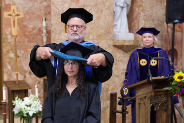 Student receives hood during ceremony